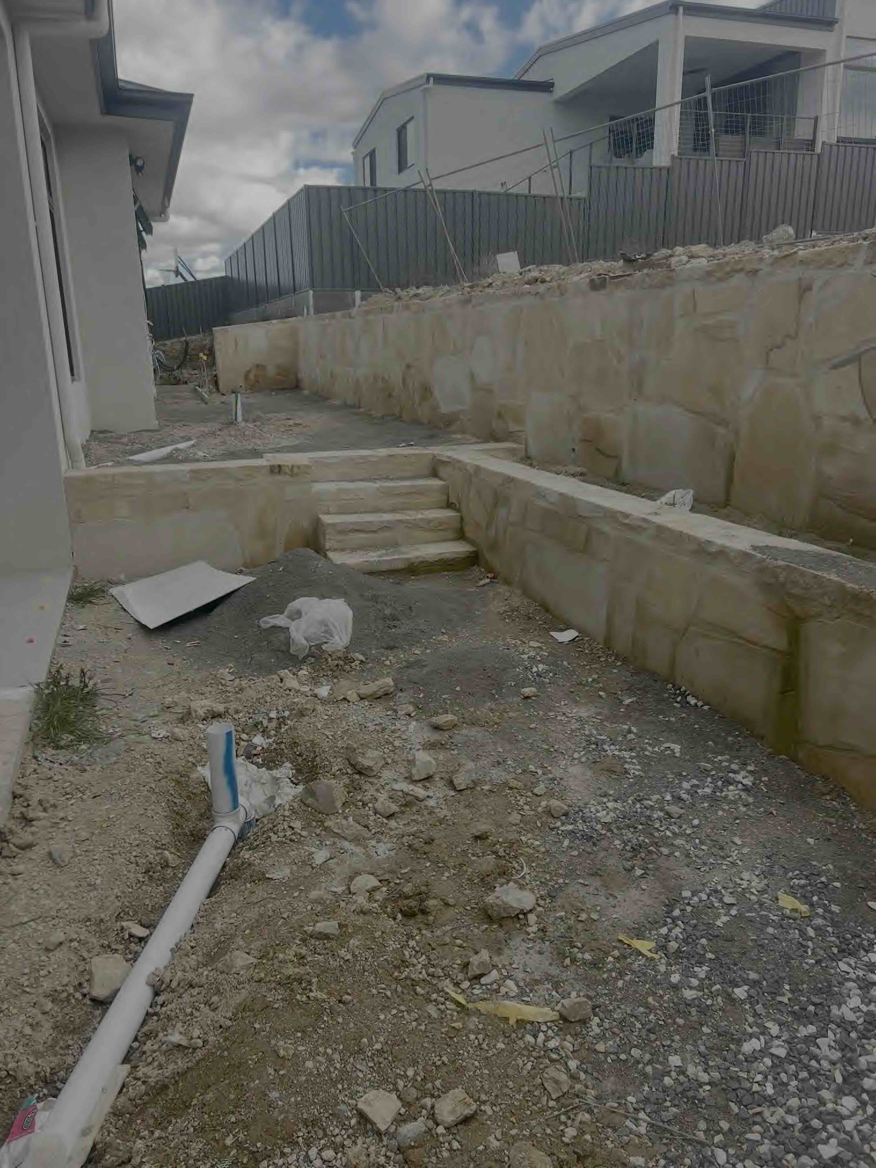 Professional sandstone wall and stone retaining wall installation in Canberra showcasing expert stone masonry craftsmanship